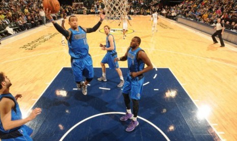 Guard Dallas Mavericks, Monta Ellis (meloncat) disaksikan rekannya, Dirk Nowitzky (belakang) dan Samuel Dalembert (kanan).