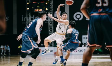 Guard Dewa United Surabaya Xaverius Prawiro mengoper bola saat berhadapan dengan pelita Jaya Bakrie Jakarta dalam laga terakhir seri reguler IBL Tokopedia 2022 di Hall Basket Senayan, Jakarta, Rabu (30/3/2022) malam.