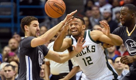 Guard Golden State Warriors, Klay Thompson (kiri) berebut bola dengan forward Milwaukee Bucks, Jabari Parker (tengah) dalam laga NBA di BMO Harris Bradley Center pada Sabtu (12/12).