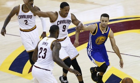 Guard Golden State Warriors, Stephen Curry (kanan) dijaga beberapa pebasket Cleveland Cavaliers pada laga final NBA 2016. Tahun ini, kedua tim kembali bertemu pada partai puncak NBA.