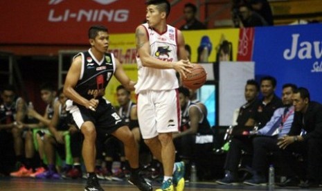 Guard Hangtuah Sumsel IM Andrie Ekayana (kiri) menjaga pemain Garuda Kukar Bandung Christ Gideon dalam laga NBL Indonesia Seri II Banding, Kamis (11/12).