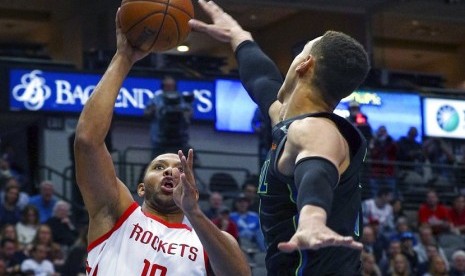 Guard Houston Rockets, Eric Gordon (nomor 10) mendapat halangan dari Dwight Powell (7) saat mencoba memasukkan bola dalam pertandingan NBA yang digelar Ahad (11/3) waktu setempat di Dallas, AS. 