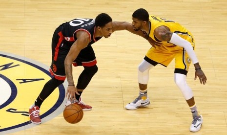 Guard Toronto Raptors DeMar DeRozan (kiri) dijaga guard Indiana Pacers Paul George.