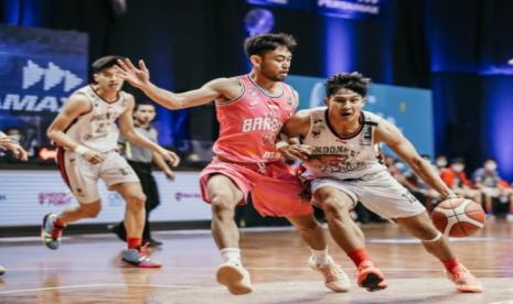 Guard Indonesia Patriots Muhammad Arighi membawa bola dihalangi point guard West Bandits Solo Widiyanta Putra Teja dalam pertandingan IBL 2021.