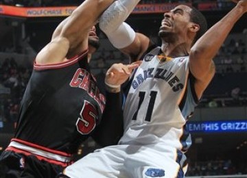 Guard Memphis Grizzlies, Mike Conley (kanan), mendapat penjagaan forward Chicago Bulls, Carlos Boozer, di pertandingan basket NBA di Memphis, Senin (16/1). 