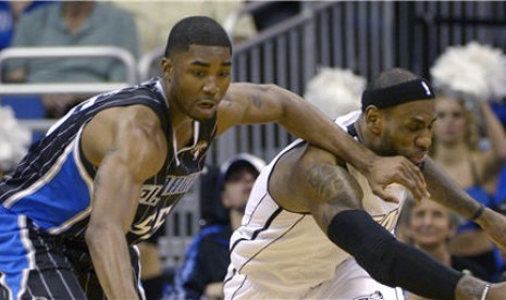 Guard Orlando Magic, E'Twaun Moore (kiri), berebut bola dengan forward Miami Heat, LeBron James, di laga NBA di Orlando, Florida, Senin (25/3). 