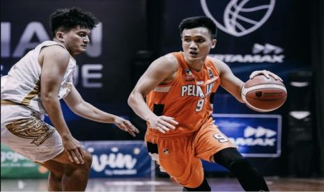 Guard Pelita Jaya Bakrie Agassi Goantara (kanan) membawa bola saat menghadapi Bima Perkasa Jogja di IBL 2021.