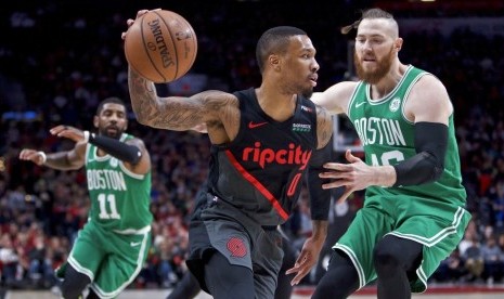 Guard Portland Trail Blazers Damian Lillard (kiri) mendribel bola dijaga center Boston Celtics Aron Baynes.