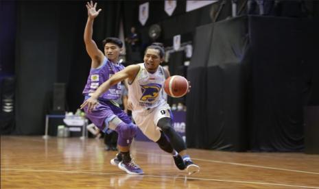 Guard Prawira Bandung Arif Hidayat (kanan) membawa bola melewati guard Amartha Hangtuah Abraham Wenas dalam pertandingan IBL 2021, Jumat (12/3)