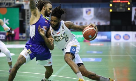 Guard Satria Muda Pertamina Gary Jacobs menjaga pemain Satya Wacana Salatiga Leshirom Montrel Williams dalam laga Seri IV IBL Pertamax 2020 di Yogyakarta, Jumat (7/2).