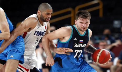 Guard Slovenia Luka Doncic membawa bola dijaga pemain Prancis Nicolas Batum.