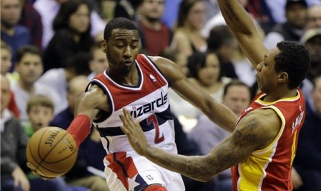 Guard Washington Wizards, John Wall (kiri), melepaskan bola saat mendapat penjagaan pemain lawan. (ilustrasi)