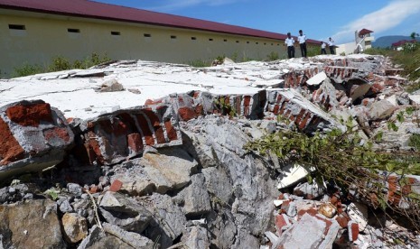 Guards partol along the 70 meters long of damaged fence in a detention center in Ingin Jaya, Aceh, after earthquakes struck the region on Wednesday, April 11, 2012. 