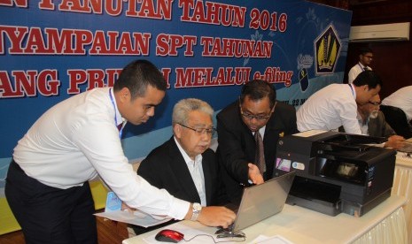 Gubernur Aceh, Zaini Abdullah (kedua kiri) didampingi petugas Kanwil Direktorat Jenderal Pajak mengoperasikan peralatan SPT e-filling sistem online saat peluncuran Pekan Panutan 2016 SPT Tahunan Wajib Pajak di Banda Aceh, Selasa (22/3).