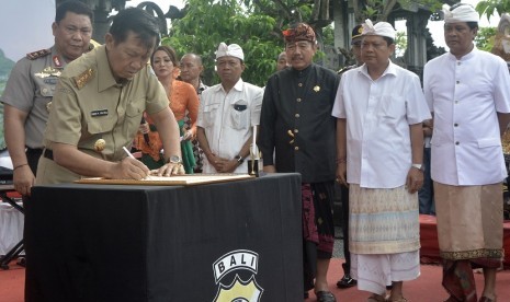 Gubernur Bali Made Mangku Pastika (kedua kiri) menandatangani naskah deklarasi disaksikan Kapolda Bali Irjen Pol Petrus Golose (kiri), Cagub Bali I Wayan Koster (keempat kanan), Cawagub Bali Tjokorda Oka Artha Ardhana Sukawati (ketiga kanan) dan Cagub Bali Ida Bagus Rai Dharmawijaya Mantra (kedua kanan), Cawagub Bali Ketut Sudikerta (kanan) saat deklarasi kesepakatan damai Pilkada Bali 2018 di Renon, Denpasar, Bali, Selasa (13/2). 