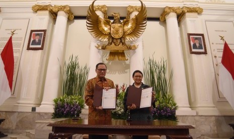 Gubernur Bank Indonesia Agus Martowardojo (kiri) bersama Menteri Luar Negeri Retno LP Marsudi (kanan) menunjukkan lembar nota kesepahaman seusai penandatanganan di Jakarta, Jumat (3/3). 