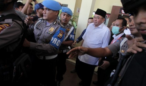 Gubernur Bengkulu Riwan Mukti (tengah) dikawal petugas kepolisian meninggalkan Reskrimsus Polda Bengkulu, Bengkulu, Selasa (20/6).