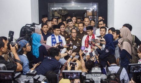 Gubernur dan Wakil Gubernur DKI Jakarta Anies Baswedan (kedua kiri) dan Sandiaga Uno (ketiga kanan) serta Kepala Kejaksaan Tinggi (Kejati) DKI Jakarta Toni Spontana (tengah) menjawab pertanyaan wartawan usai melakukan pertemuan tertutup di Kantor Kejati DKI Jakarta, Jalan HR Rasuna Said, Jakarta, Kamis (19/10). 