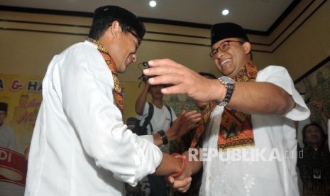 Gubernur dan Wakil Gubernur DKI Jakarta Terpilih Anies Baswedan (kanan) dan Sandiaga Uno (kiri) menghadiri acara selamatan dan doa bersama yang digelar Partai Keadilan Sejahtera (PKS) di Hotel Grand Cempaka, Jakarta, Ahad (15/10). 