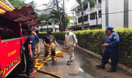 Gubernur DKI Anies Baswedan berbincang dengan petugas yang sedang menangani genangan di kawasan Kemang, Jakarta Selatan, Ahad (21/2).