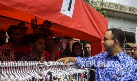 Gubernur DKI Jakarta Anies Baswedan berbincang dengan pedagang kaki lima saat meninjau Jalan Jatibaru Raya, Tanah Abang, Jakarta, Jumat (22/12).