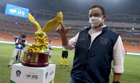 Gubernur DKI Jakarta Anies Baswedan berpose di dekat trofi sebelum pertandingan Barcelona U-18 melawan Atletico Madrid U-18 pada final International Youth Championship 2021 di Jakarta International Stadium, Jakarta, Selasa (19/4/2022).