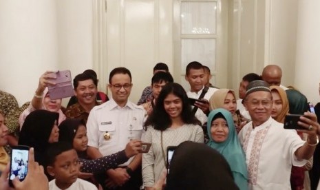 Gubernur DKI Jakarta, Anies Baswedan bersama perwakilan pemudik program mudik gratis Pemprov DKI Jakarta. Politisi PSI William Aditya kritisi ada kaos 'Anies Presiden' di acara mudik gratis.