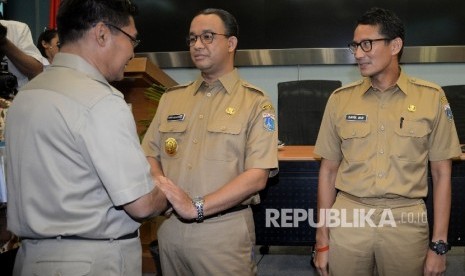 Gubernur DKI Jakarta Anies Baswedan dan Wakil Gubenrur Sandiaga Uno bersalaman usai rapat pengenalan SKPD di Ruang Pola Blok G, Balai Kota, Jakarta, Selasa (17/10)