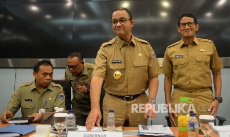 Gubernur DKI Jakarta Anies Baswedan dan Wakil Gubernur Sandiaga Uno usai rapat pengenalan SKPD di Ruang Pola Blok G, Balai Kota, Jakarta, Selasa (17/10).