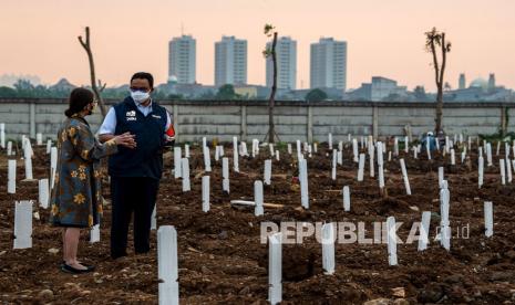 Gubernur DKI Jakarta Anies Baswedan (kanan) berbincang dengan Kepala Dinas Pertamanan dan Hutan Kota Provinsi DKI Jakarta, Suzi Marsitawati (kiri) saat meninjau area pemakaman khusus COVID-19 di TPU Rorotan, Cilincing, Jakarta Utara, Kamis (15/7/2021). Anies Baswedan menyampaikan, pihaknya memakamkan jenazah dengan menggunakan protokol COVID-19 hingga mencapai 306 jenazah. 