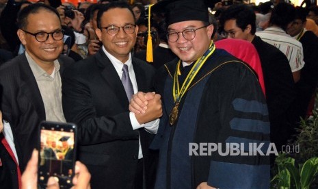 Gubernur DKI Jakarta Anies Baswedan (kedua kiri) berjabat tangan dengan Rektor IPB Arif Satria (kanan) usai orasi ilmiah sidang terbuka pengukuhan guru besar IPB di Auditorium Fakultas Ekonomi dan Manajemen IPB, Kampus IPB Dramaga, Kabupaten Bogor, Jawa Barat, Sabtu (11/1/2020).