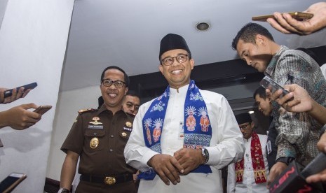 Gubernur DKI Jakarta Anies Baswedan (kedua kiri) bersama Kepala Kejaksaan Tinggi (Kejati) DKI Jakarta Toni Spontana (kiri) bergega susai melakukan pertemuan tertutup di Kantor Kejati DKI Jakarta, Jalan HR Rasuna Said, Jakarta, Kamis (19/10). 