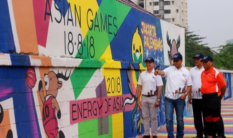 Gubernur DKI Jakarta Anies Baswedan (kedua kiri) bersama Sekretaris Daerah Provinsi DKI Jakarta Saefullah (kanan), Walikota Jakarta Pusat Bayu Meghantara (kedua kanan), dan Presiden Direktur PT ICI Paints Indonesia Jun De Dios (kiri) melihat mural Asian Games 2018 di Kampung Tematik, Kemayoran, Jakarta, Sabtu (21/7). 