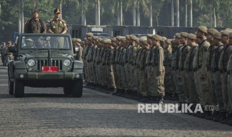 Gubernur DKI Jakarta Anies Baswedan (kedua kiri) meninjau pasukan dalam Apel Besar Rotasi Satuan Polisi Pamong Praja (Satpol PP) DKI Jakarta di Monumen Nasional (Monas) , Jakarta, Jumat (29/12).