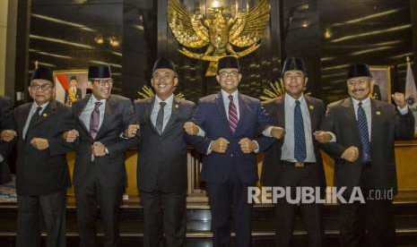 Gubernur DKI Jakarta Anies Baswedan (ketiga kanan), bersama Ketua DPRD DKI Jakarta Prasetyo Edi Marsudi (ketiga kiri) dan Wakil Ketua DPRD DKI Jakarta Mohamad Taufik (kiri), Lulung AL (kedua kanan) dan Mayjen TNI (Purn) Ferrial Sofyan (kanan) serta Bakal calon Wakil Presiden Sandiaga Uno (kedua kiri) saling bergandengan tangan usai Rapat Paripurna tentang pembacaan surat pengunduran diri Wakil Gubernur DKI Jakarta di DPRD DKI Jakarta, Senin (27/8). 