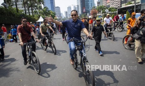 Gubernur DKI Jakarta Anies Baswedan melambaikan tangan saat meninjau Hari Bebas Kendaraan Bermotor (HBKB) di kawasan Bundaran HI, Jakarta, Ahad (3/11/2019). 