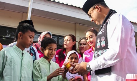 Gubernur DKI Jakarta Anies Baswedan memberikan susu dan telur rebus kepada siswa SDN 12 Pagi Cilandak saat mempromosikan program Revolusi Putih di SDN 12 Cilandak Barat, Jalan Taman Wijaya Kusuma III, Jakarta, Jumat (24/11). 