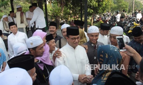 Gubernur DKI Jakarta Anies Baswedan (tengah) bersalaman dengan warga usai menghadiri kegiatan halalbihalal dan doa bersama saat perayaan Idul fitri hari kedua di Makam Wakaf Muslim, Lebak Bulus, Jakarta, Kamis (6/6/2019).