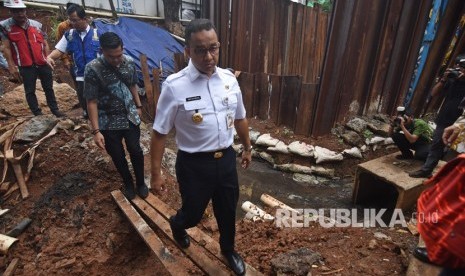 Gubernur DKI Jakarta Anies Baswedan (tengah) meninjau titik banjir yang bersebelahan dengan proyek LRT di Underpass Cawang, Jakarta, Kamis (4/4/2019). 