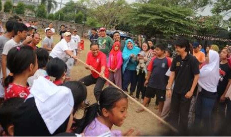 Gubernur DKI Jakarta Anies Rasyid Baswedan mengikuti perlombaan tarik tambang di lingkungan kediamannya di Jalan Lebak Bulus 1, Cilandak Barat, Jakarta Selatan, Jumat (17/8). Dia melakukan selebrasi usai menang pada permainan pertama.