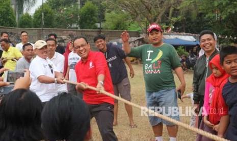 Gubernur DKI Jakarta Anies Rasyid Baswedan mengikuti perlombaan tarik tambang di lingkungan kediamannya di Jalan Lebak Bulus 1, Cilandak Barat, Jakarta Selatan, Jumat (17/8). Dia melakukan selebrasi usai menang pada permainan pertama.