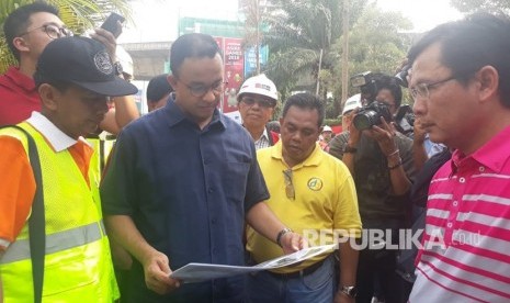 Gubernur DKI Jakarta Anies Rasyid Baswedan meninjau proyek penataan trotoar dan jalan di ruas Jalan Sudirman hingga Jalan MH Thamrin, Jakarta Pusat, Ahad (22/7).