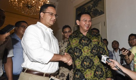 Dua mantan gubernur DKI Jakarta Basuki Tjahaja Purnama atau Ahok (kanan) berjabat tangan dengan Anies Baswedan (kiri) sebelum melakukan pertemuan di Balai Kota, Jakarta, Kamis (20/4). 