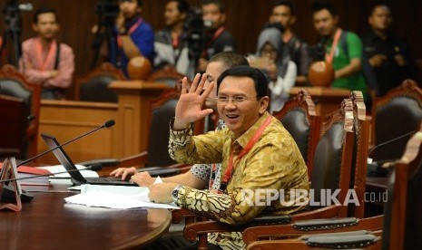 Gubernur DKI Jakarta Basuki Tjahaja Purnama atau Ahok melambaikan tangan ke arah wartawan saat mengikuti sidang perdana di Gedung Mahkamah Konstitusi (MK), Jakarta, Senin (22/8).  (Republika/Raisan Al Farisi)