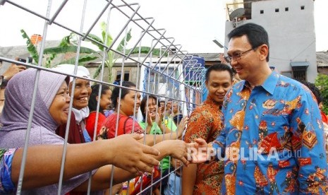 Gubernur DKI Jakarta Basuki Tjahaja Purnama bersalaman dengan warga saat membuka Ruang Publik Terpadu Ramah Anak (RPTRA) Pulo Gundul di Jalan Kramat, Johar Baru, Jakarta Pusat, Kamis (17/3). 