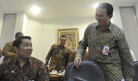 Gubernur DKI Jakarta Basuki Tjahaja Purnama (kanan) berbincang dengan Walikota Bandung Ridwan Kamil (kiri) sebelum mengikuti rapat terbatas kabinet yang dipimpin Presiden Joko Widodo di Kantor Presiden, Jakarta, Kamis (2/4).