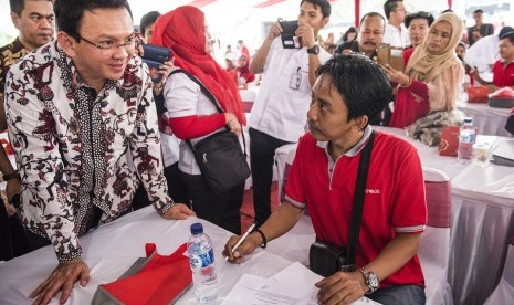 Gubernur DKI Jakarta Basuki Tjahaja Purnama (kiri) menyaksikan penandatanganan penyaluran kredit kepada pedagang di Pasar Induk Kramat Jati, Jakarta, Jumat (4/3).