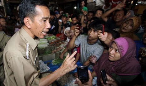 Gubernur DKI Jakarta, Joko Widodo berbincang dengan pedagang pasar ketika melakukan inspeksi mendadak di Pasar Galur, Jakarta Pusat, Rabu (24/10). Jokowi menegaskan akan membangun kembali pasar tersebut dan menggratiskan sewa kios pasar itu.