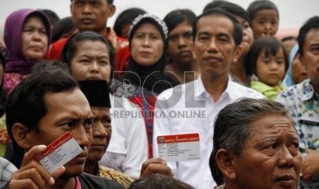   Gubernur DKI Jakarta, Joko Widodo berfoto bersama dengan warga usai membagikan Kartu Jakarta Sehat di kelurahan Marunda, Jakarta Utara, Senin (12/11).   (Adhi Wicaksono)