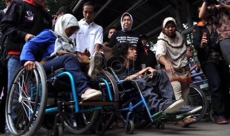   Gubernur DKI Jakarta Joko Widodo bersama sejumlah penyandang disabilitas melakukan uji coba menggunakan bus Transjakarta di halte Balaikota, Jakarta Pusat, Kamis (4/7).   (Republika/Rakhmawaty La'lang)